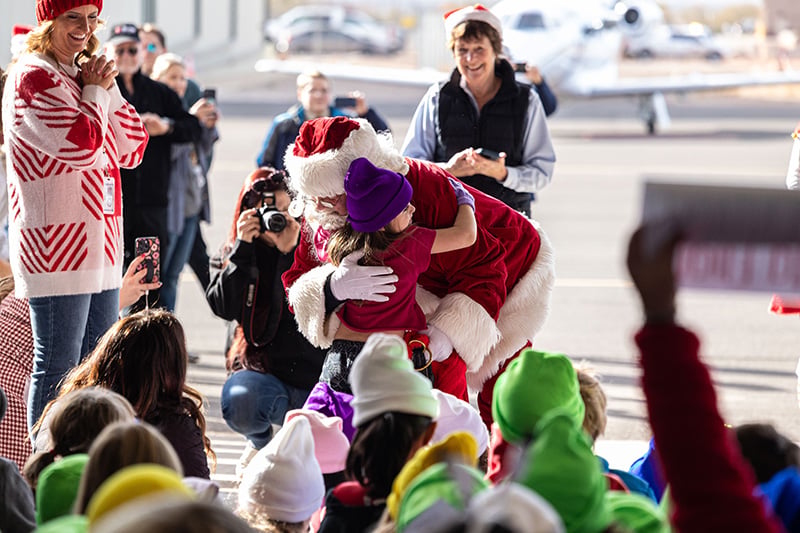 Santa hugging a small child during the annual Santa Flight in Utah
